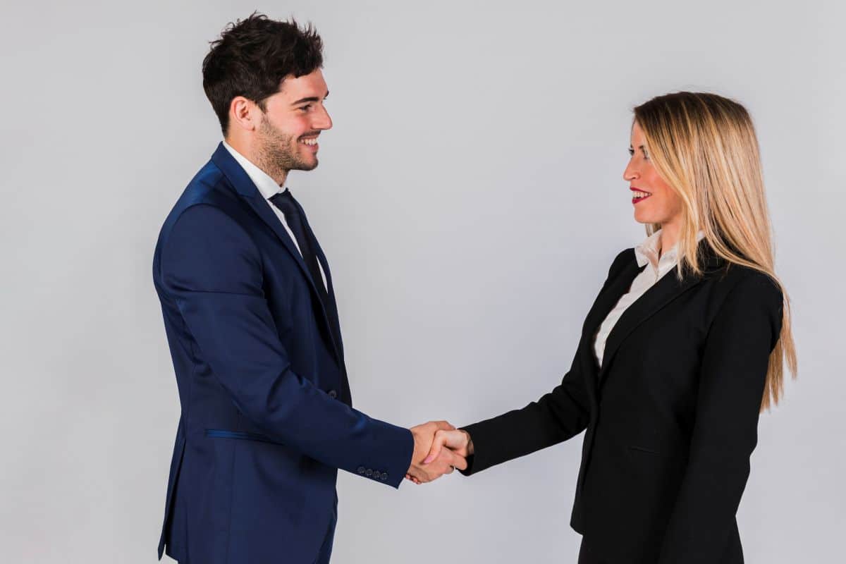 Aperto de mãos entre executivos em ambiente corporativo.