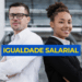 Homem de camisa branca e óculos e mulher negra de blazer preto, lado a lado, com faixa azul escrito "Igualdade Salarial".