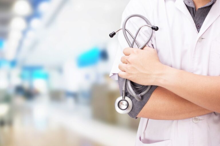 Profissional de saúde com estetoscópio em ambiente hospitalar.