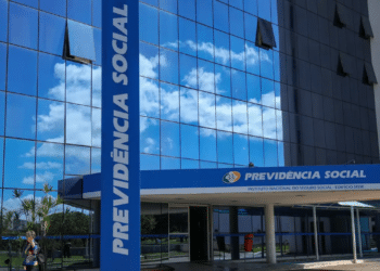 Fachada espelhada do edifício sede da Previdência Social com céu azul refletido