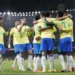Jogadores da Seleção Brasileira comemoram gol abraçados em campo iluminado