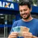 Homem segurando cédulas em frente a agência da Caixa, representando a confirmação de depósitos de até R$ 1.078,01 para CPFs finais 0 a 9.
