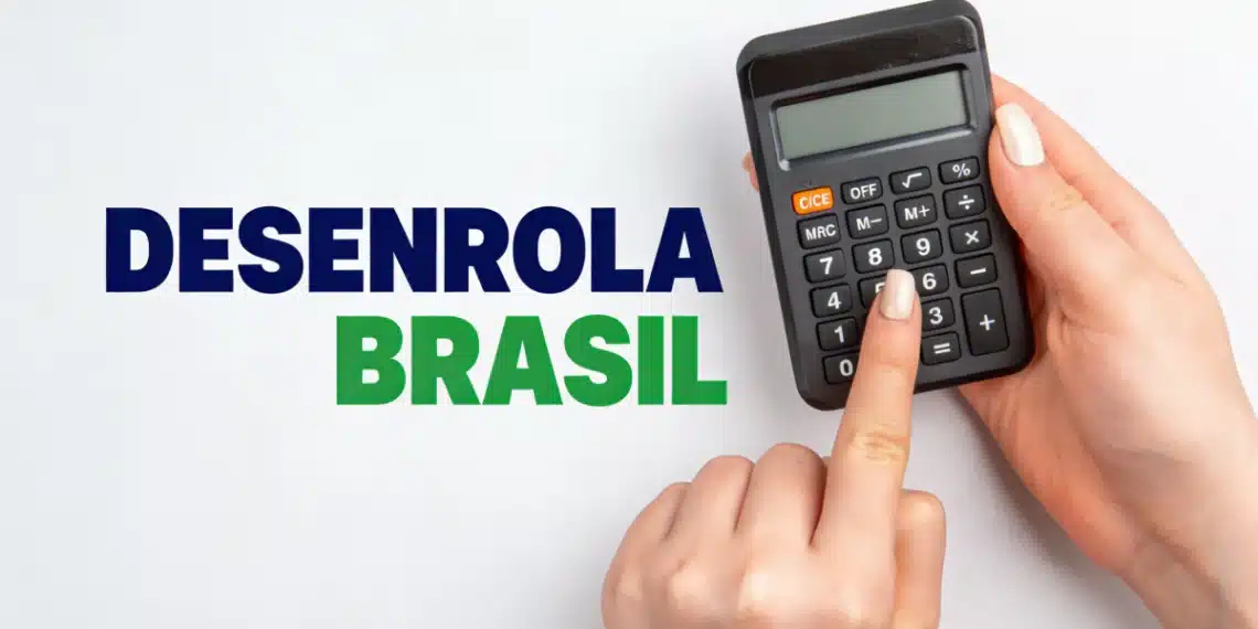 Mãos digitando em calculadora preta ao lado da inscrição Desenrola Brasil em letras azuis e verdes sobre fundo branco