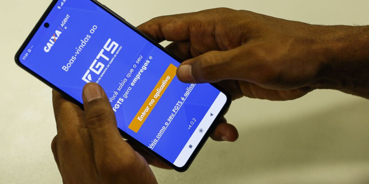 Desenrola FGTS consulta saldo: mãos seguram celular com tela de boas-vindas do aplicativo FGTS da Caixa aberta.