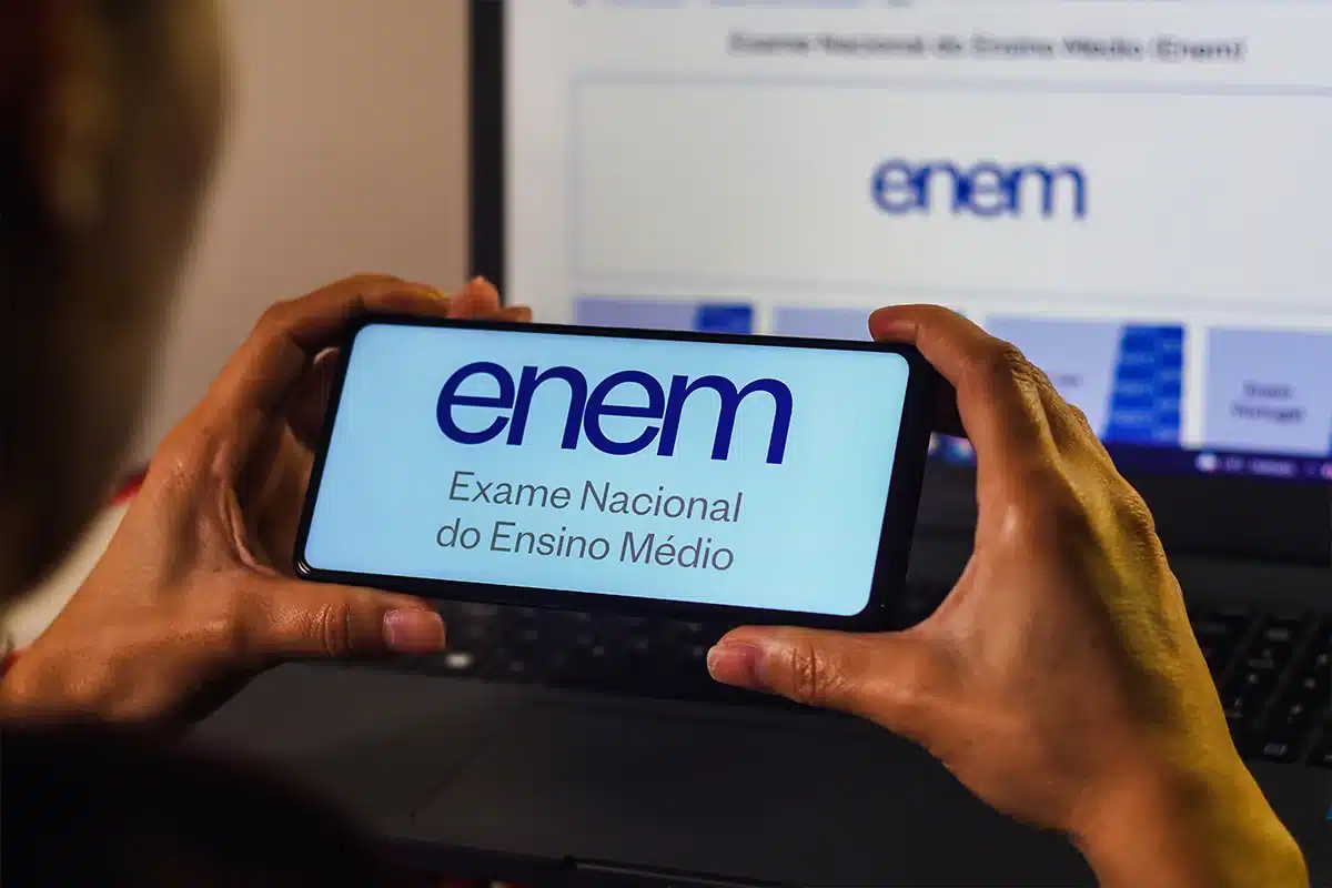 Pessoa segurando celular com página do Enem aberta, representando os conteúdos mais cobrados no exame para a preparação em 2026