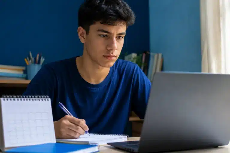 Estudante brasileiro atento diante do notebook, representando o acompanhamento da abertura das inscrições do Enem 2026.