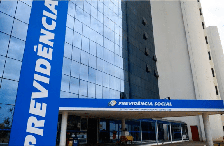 Fachada do prédio do INSS com letreiro azul "Previdência Social" e vidros espelhados em Brasília