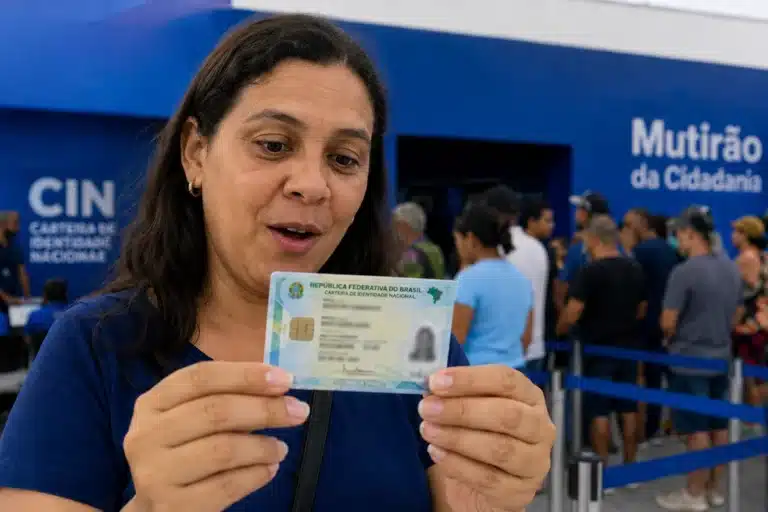 Mulher observando a nova Carteira de Identidade Nacional, representando o mutirão para emissão do documento a partir desta segunda-feira (1º).