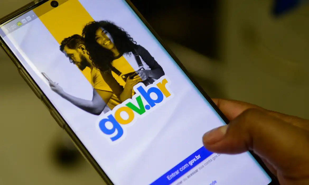  Mão segura smartphone com a tela de login da conta gov.br aberta no aplicativo