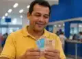 Trabalhador brasileiro conferindo cédulas de reais, simbolizando pagamento de até R$ 3.981 do PIS/Pasep em junho