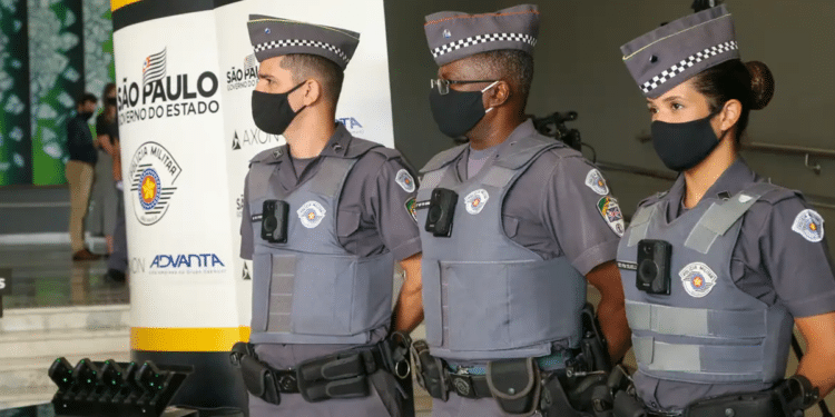 Três policiais militares de São Paulo, uniformizados e com coletes, em evento oficial do governo estadual